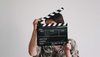 a person holding a black clapper board