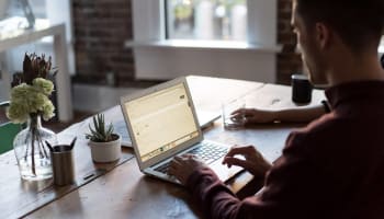 people sitting at a table using a laptop
