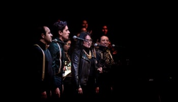 a group of people singing into microphones