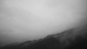 a foggy mountain range with trees