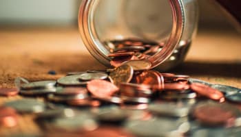 a jar of coins spilling out of it