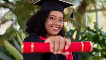 a person in a graduation cap and gown holding a diploma
