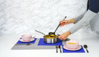 a person cooking soup in a pot