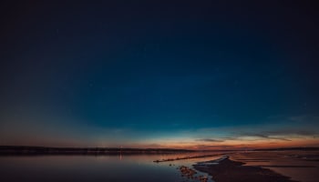 a beach at night with stars in the sky