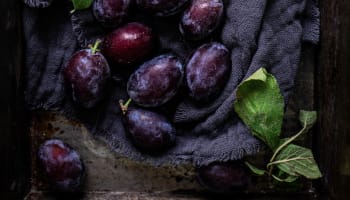 a group of plums with leaves