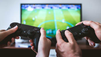 a pair of hands holding game controllers