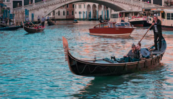 Rialto Bridge over water with boats and people on it