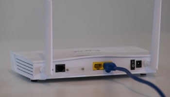 a white router with blue cables plugged into it