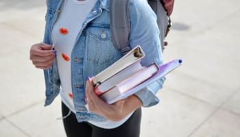 a person carrying books and a backpack