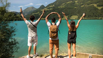 a group of people standing on a rock with their arms up in the air