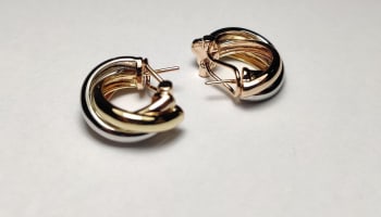 a pair of gold and silver earrings
