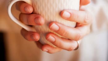 a person holding a white mug