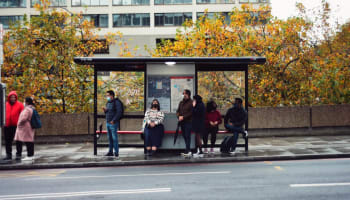 a group of people sitting on a bus stop