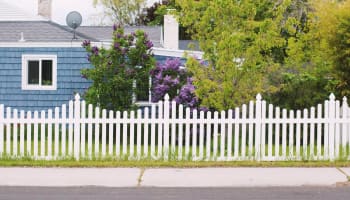 a white picket fence in front of a house
