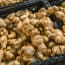 a group of brown ginger root in black bins