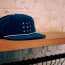 a blue hat on a wood shelf