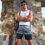 a person with a bandana and sunglasses standing in front of a stone wall