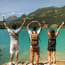 a group of people standing on a rock with their arms up in the air