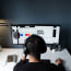 a person wearing headphones sitting at a desk with a computer