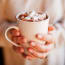 a person holding a white mug