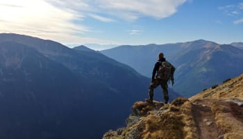a person standing on a cliff overlooking a valley