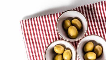 a group of bowls with green olives