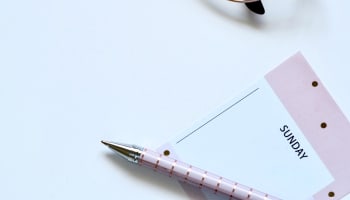 a pen and a notepad on a white surface