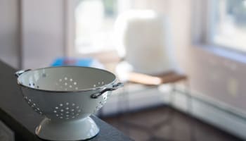 a white colander on a counter