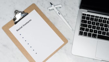 a clipboard and a laptop on a marble surface