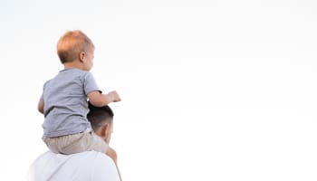 a person carrying a child on his shoulders