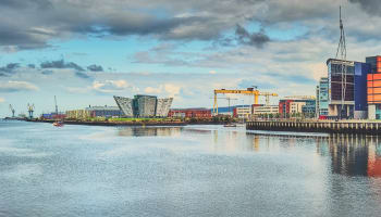 a body of water with buildings and a crane