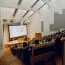 a person standing in front of a large screen in a lecture hall