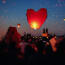 a red heart shaped lantern in the sky