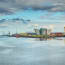 a body of water with buildings and a crane