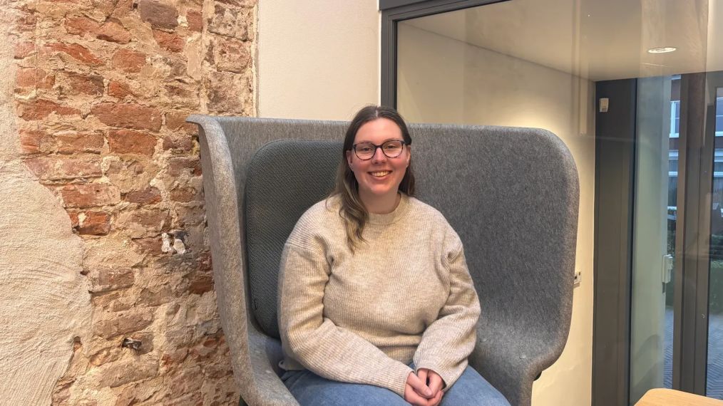 meisje die lacht en op een stoel zit