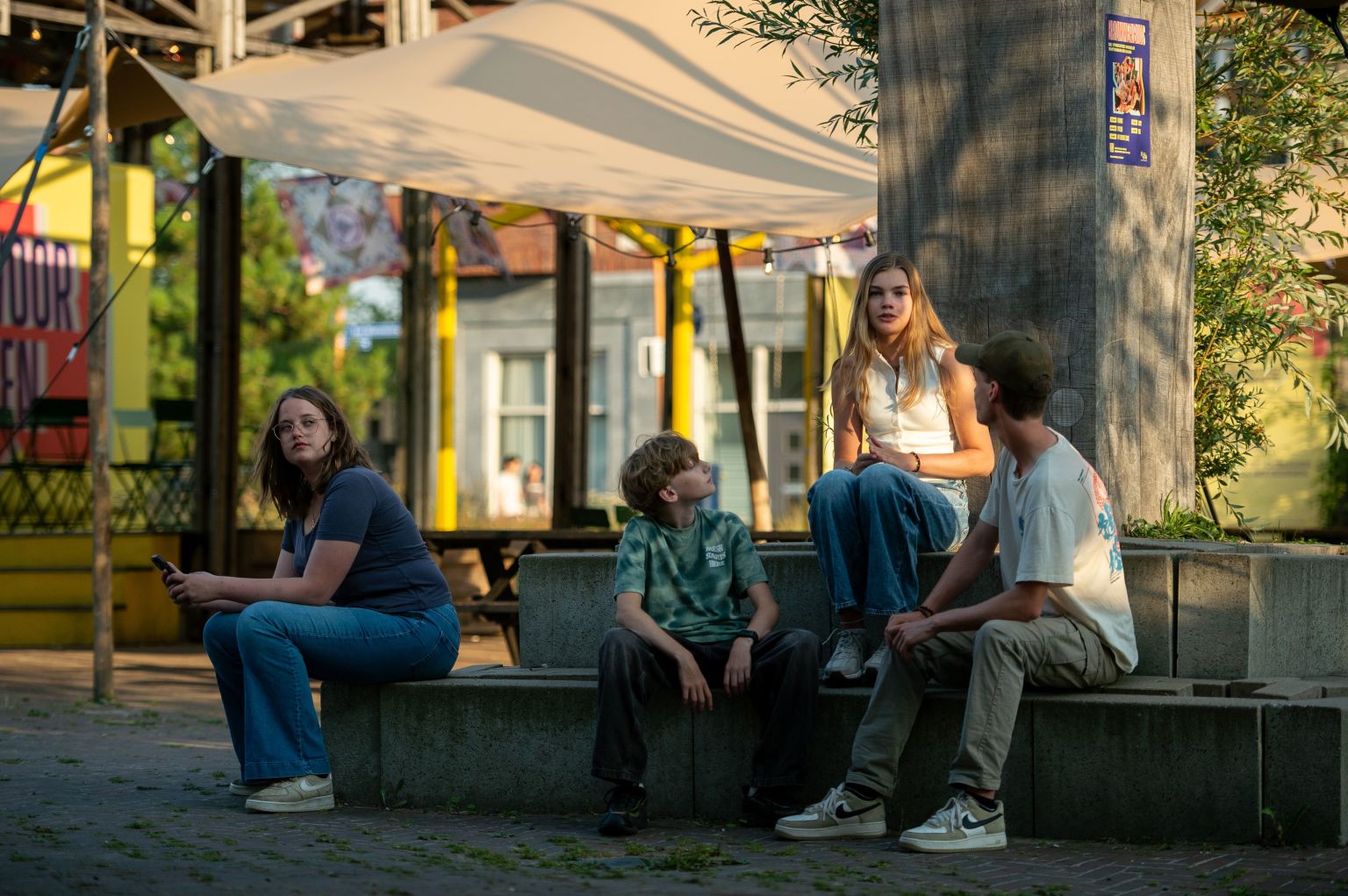 jongeren die met elkaar op een bankje zitten