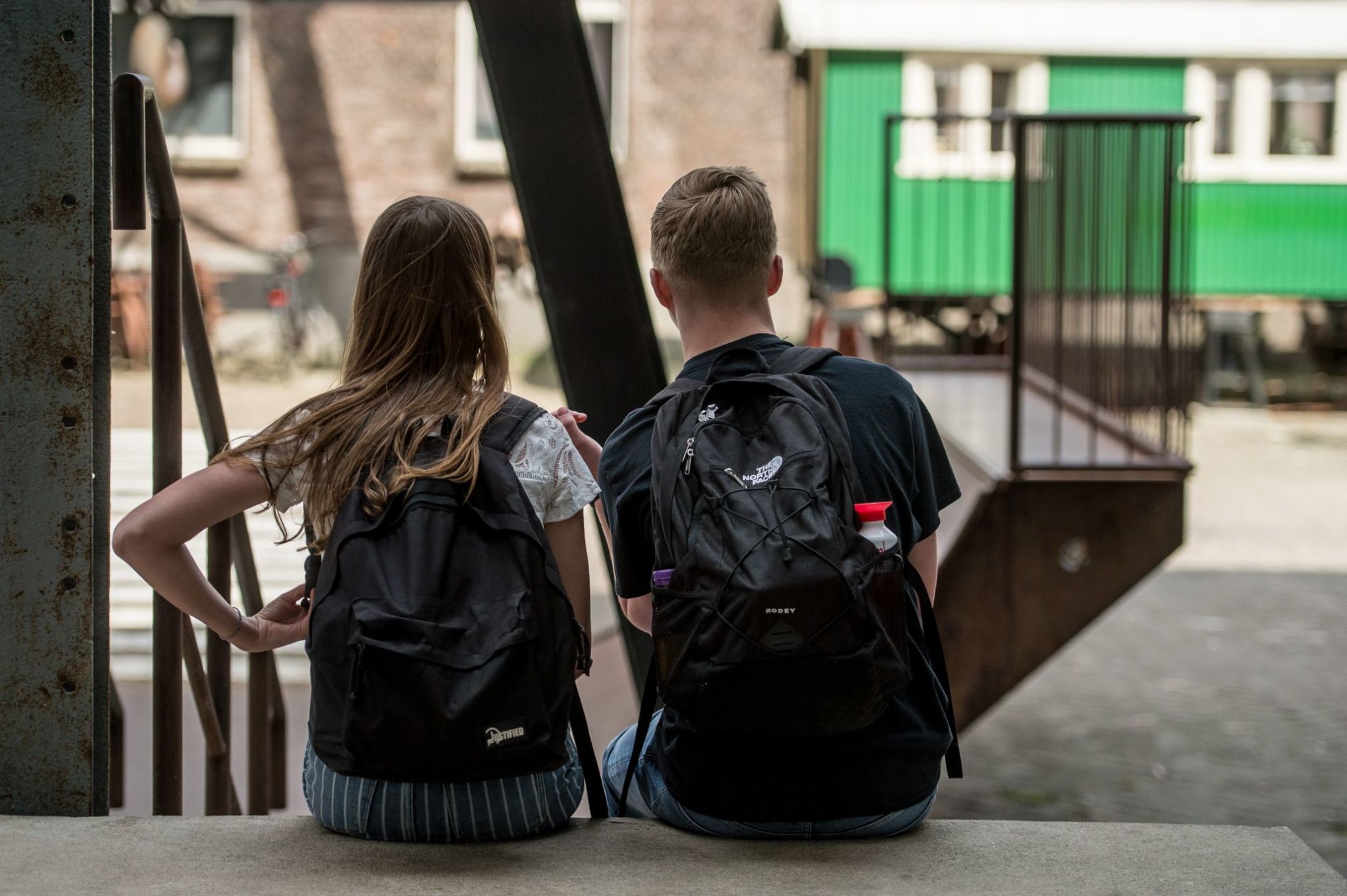 twee jongeren die samen op een trap zitten