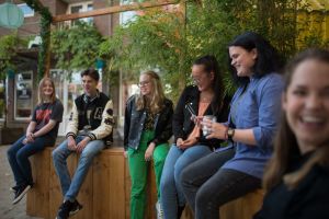 Join Us jongeren bij elkaar op een houten muurtje