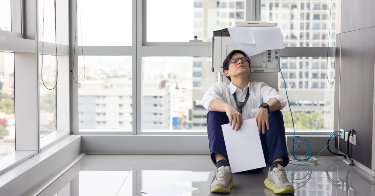 asian male sitting on floor in office in frustration