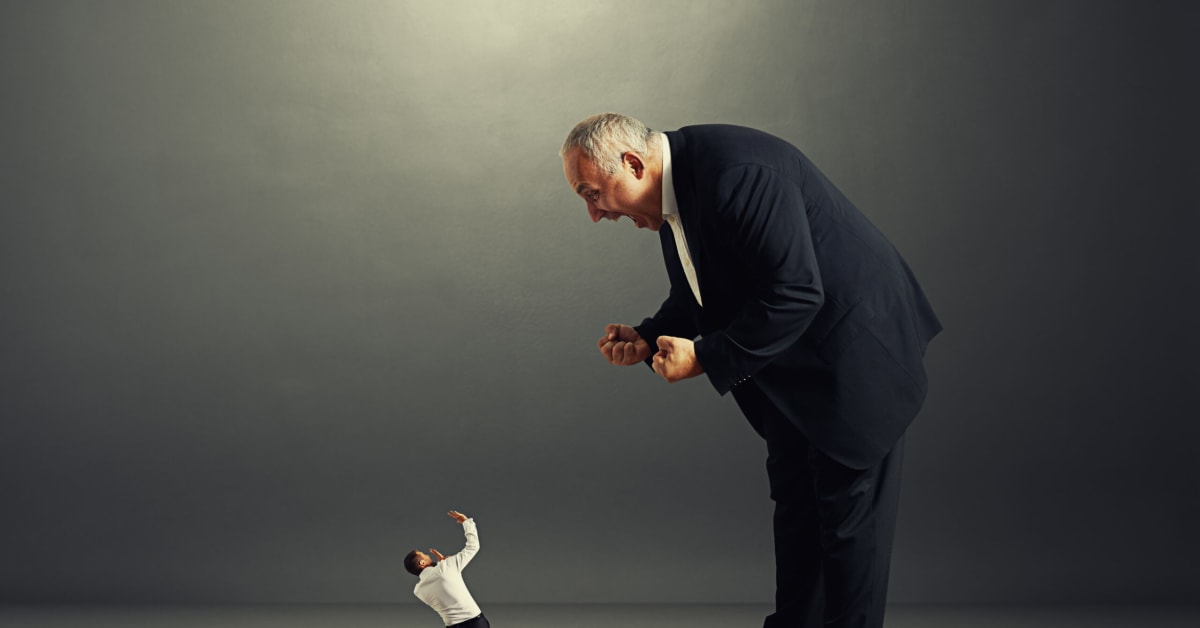 large man in suit looking down and yelling at small man