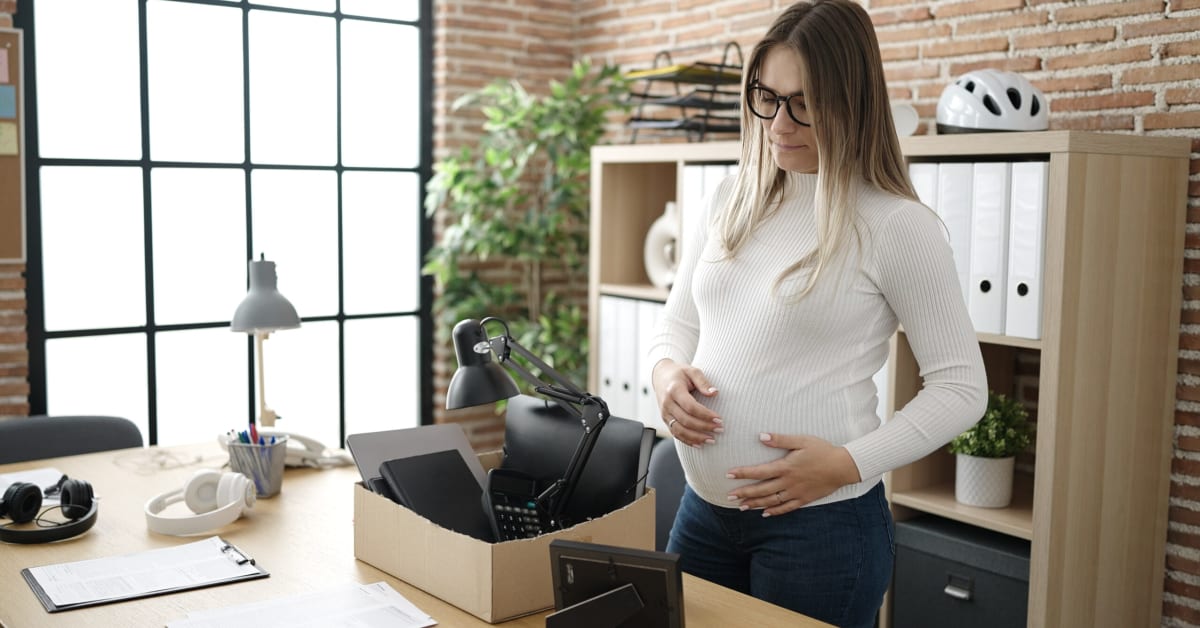 Pregnant woman packing up her things after a wrongful termination Pregnant woman packing up her things after a wrongful termination