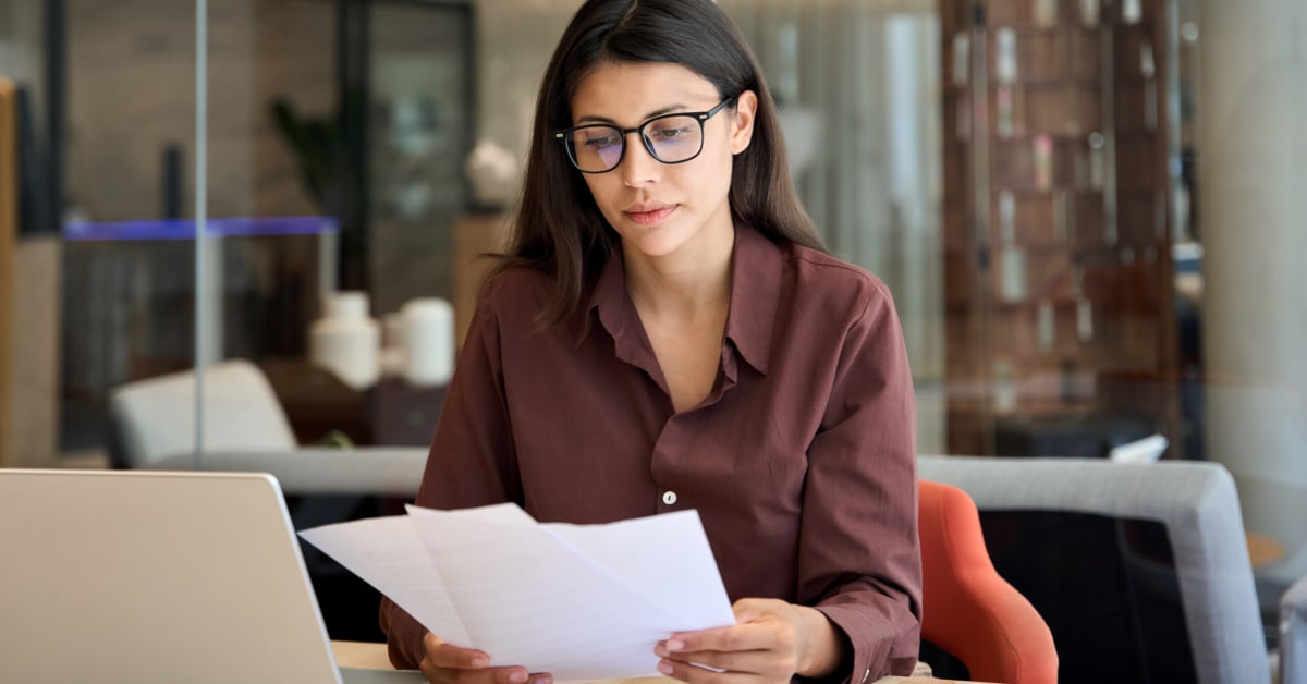 image of a business woman at desk looking through papers image of a business woman at desk looking through papers