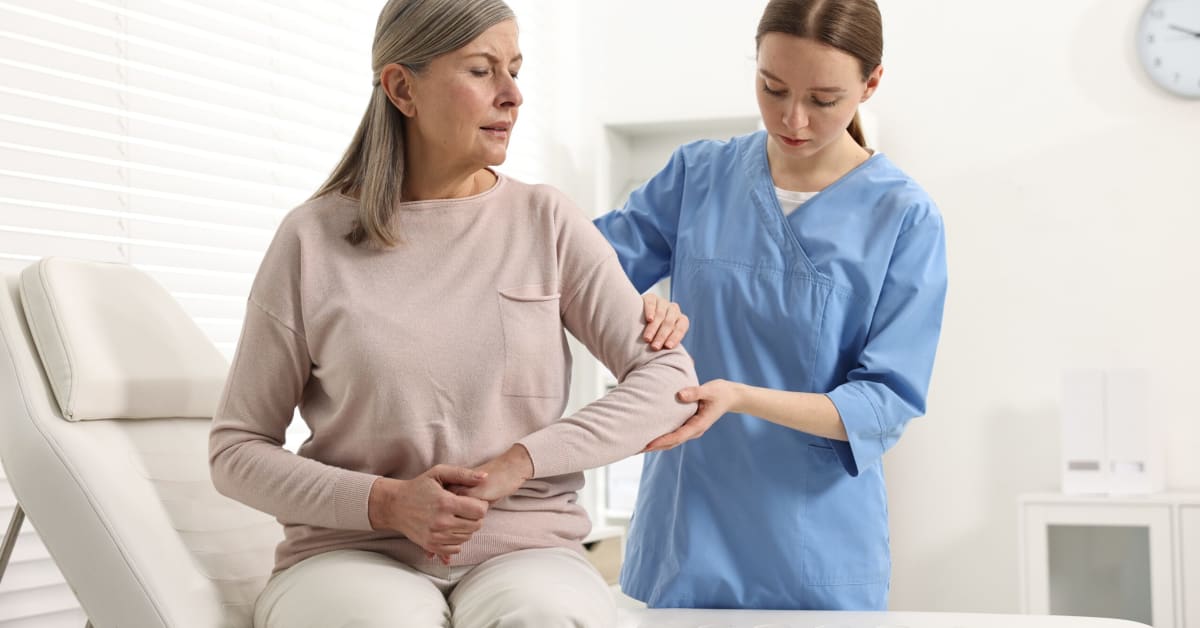 image of woman at doctor holding elbow with nurse
