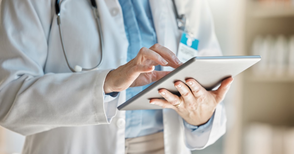 close up of a doctor in coat with tablet in hand