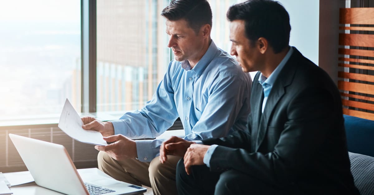 two businessmen reviewing papers in office