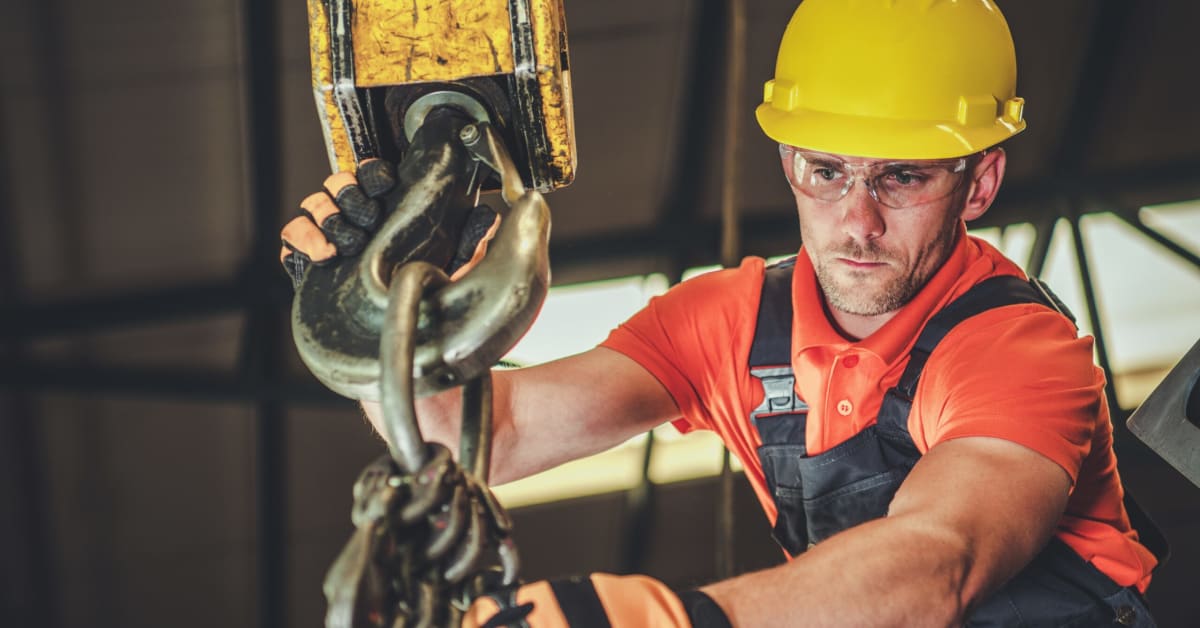 man in hardhat working crane rigging
