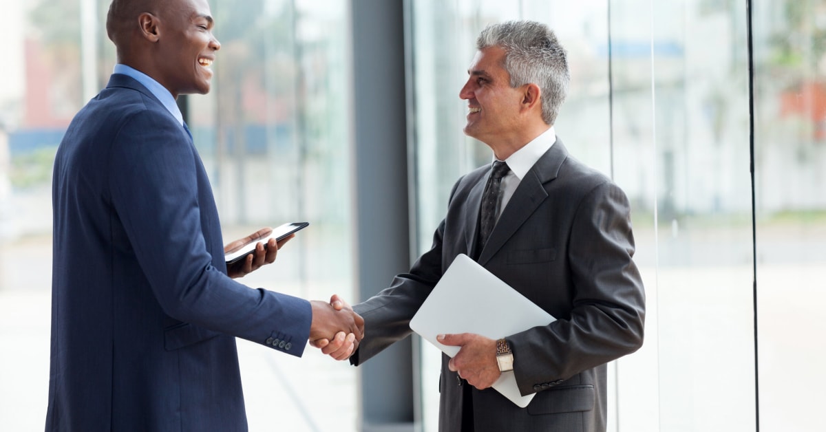 two men in suits shaking hands