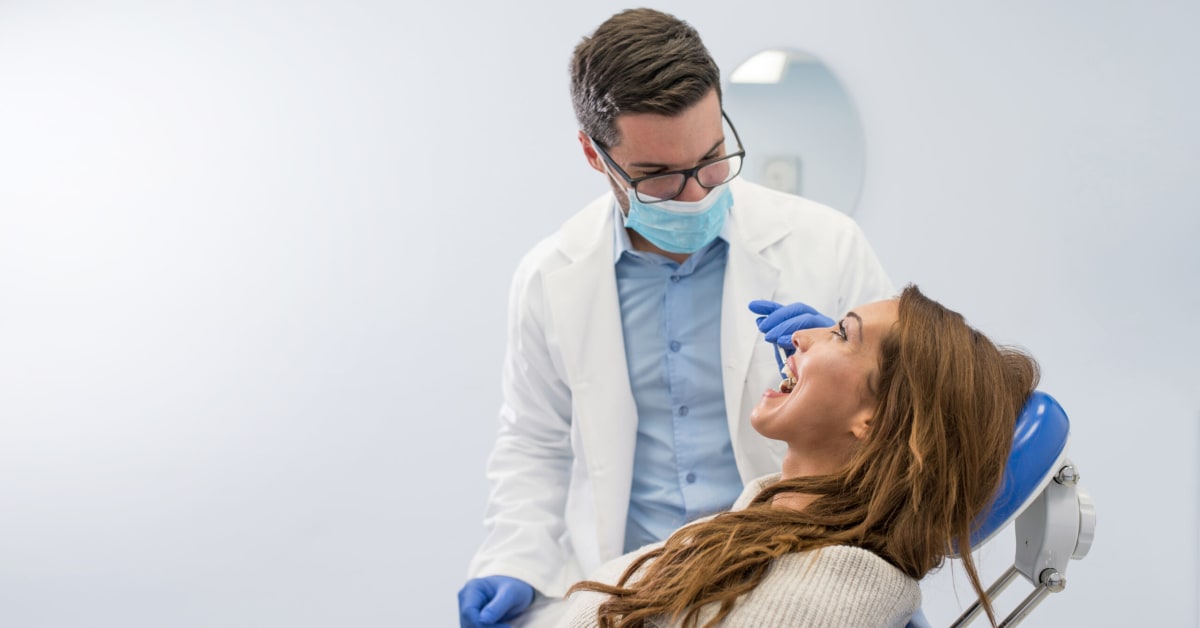 dentist tending to patient with open mouth dentist tending to patient with open mouth