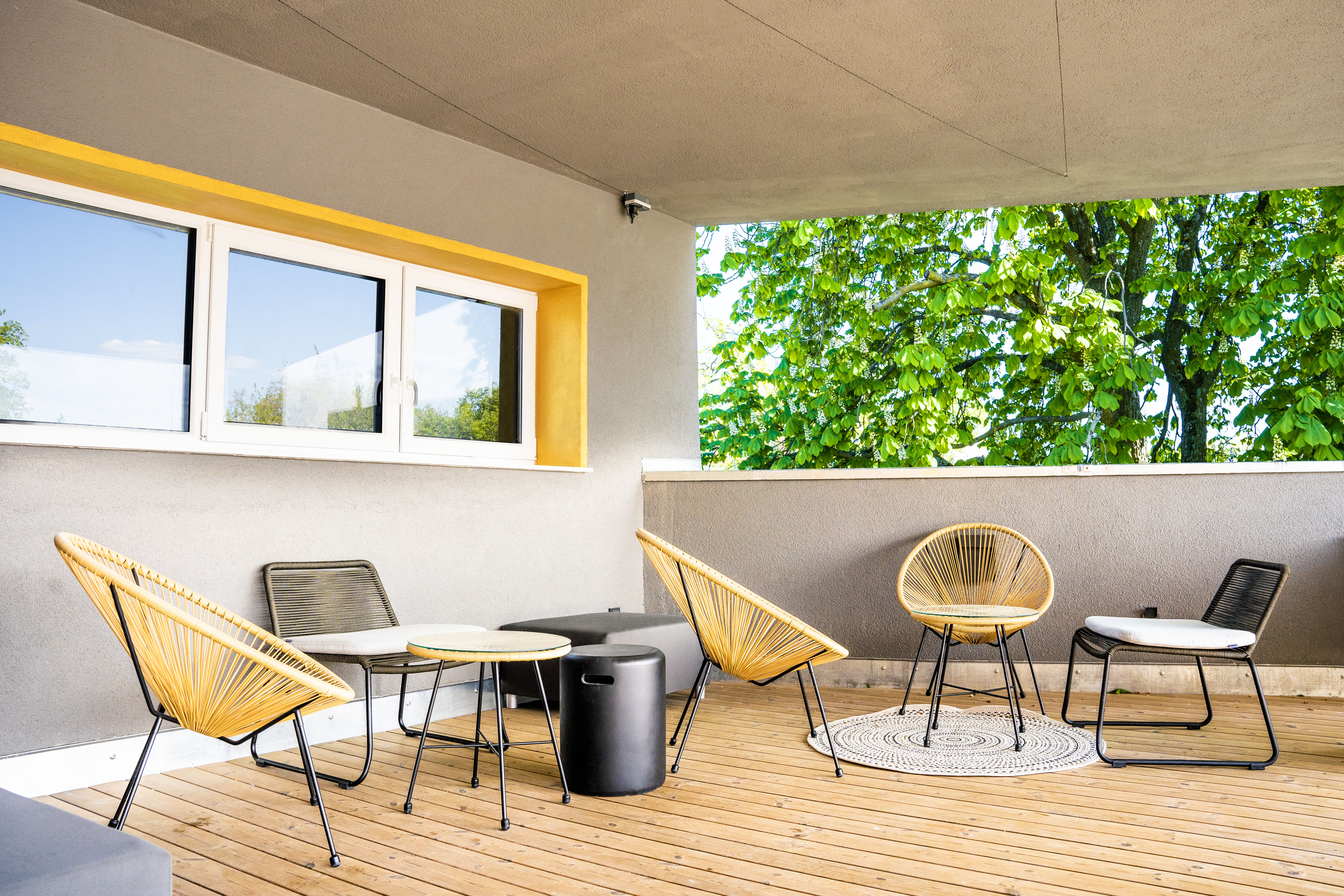 Die Terrasse mit gelben Stühlen und Blick ins Grüne