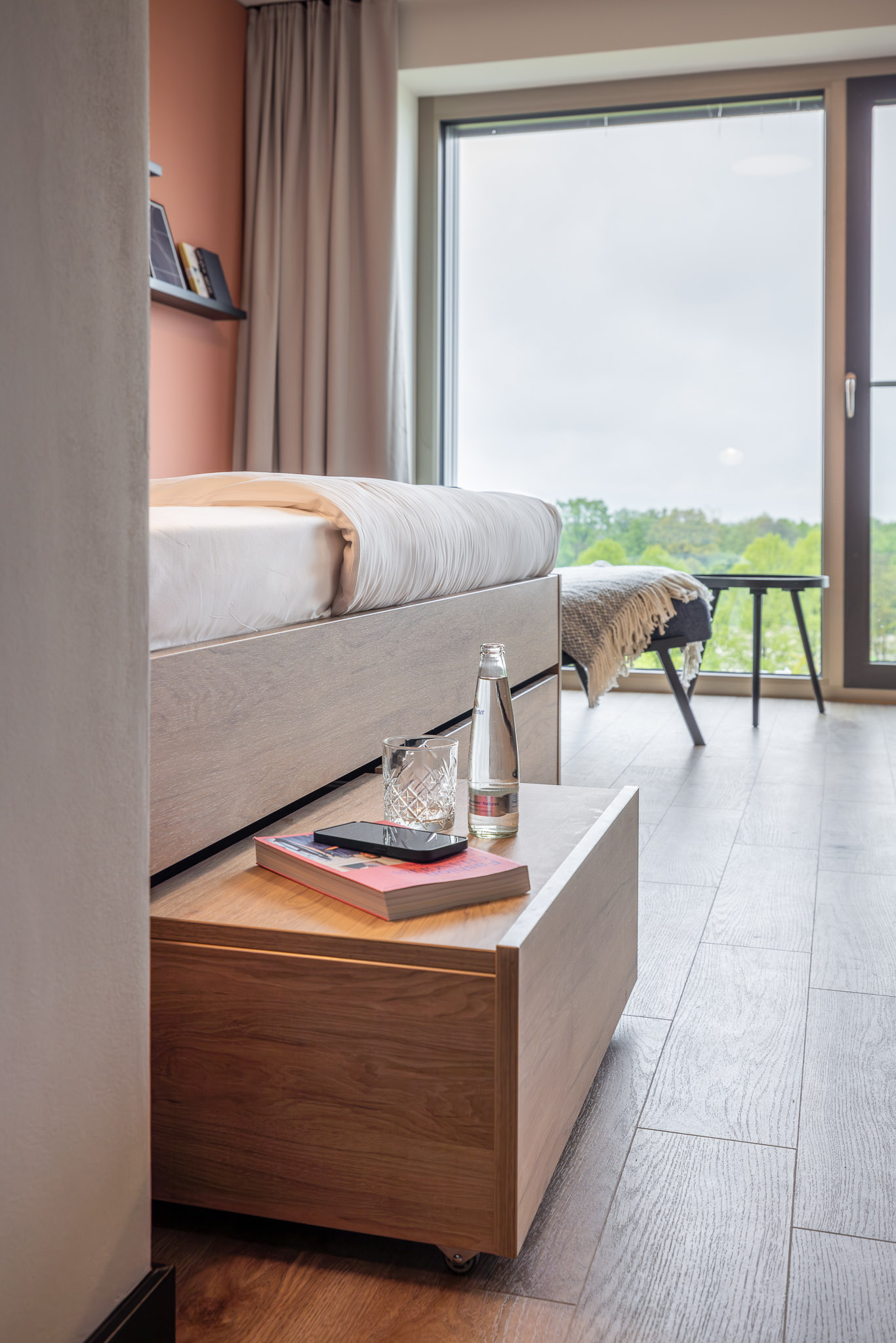 Light-filled coliving apartment at The Base Munich - detail on pull-out nightstand and storage solution